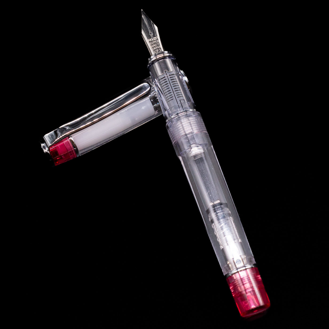 Pilot Prera Fountain Pen - Red laying on top of its cap in a crossed position showing full view of the entire uncapped pen.