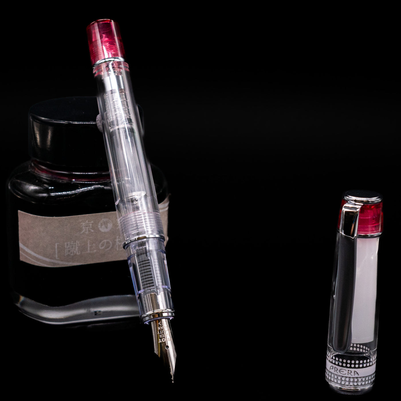 Pilot Prera Fountain Pen - Red leaning on an ink bottle uncapped showcasing the detailing on the nib.