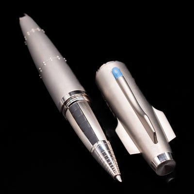 A full view of the Romain Jerome Moon Fighter Rollerball Pen - Heavy Metal uncapped, with its cap laying next to the pen. 