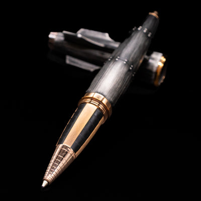 Romain Jerome Moon Fighter Rollerball Pen - Vintage Finish laying across its own cap, crossed, with a focus on the tip.