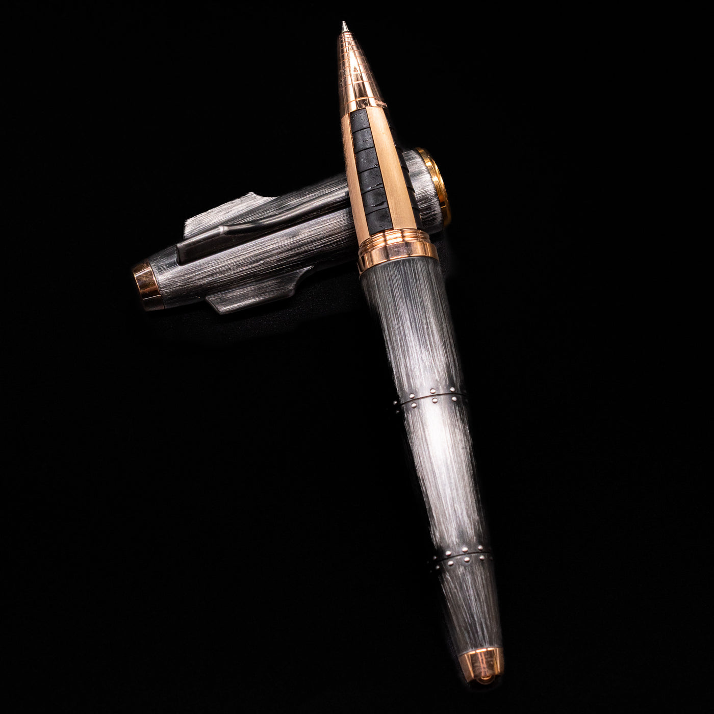 Romain Jerome Moon Fighter Rollerball Pen - Vintage Finish laying on top of its cap in a crossed position showing full view of the entire uncapped pen.