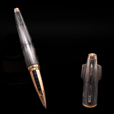 Romain Jerome Moon Fighter Rollerball Pen - Vintage Finish leaning on an ink bottle uncapped showcasing the detailing on the tip.