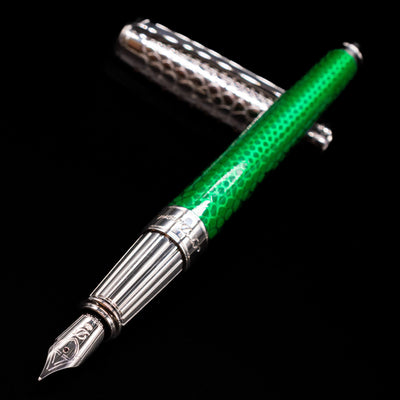ST Dupont Line D Eternity Snake Skin Fountain Pen - Green laying across its own cap, crossed, with a focus on the nib.