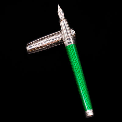 ST Dupont Line D Eternity Snake Skin Fountain Pen - Green laying on top of its cap in a crossed position showing full view of the entire uncapped pen.