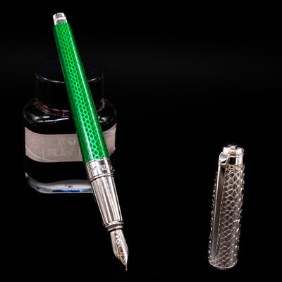 ST Dupont Line D Eternity Snake Skin Fountain Pen - Green leaning on an ink bottle uncapped showcasing the detailing on the nib.