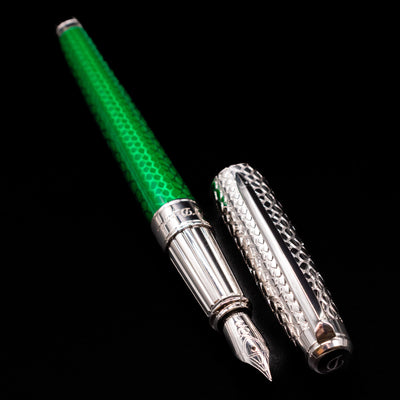 A full view of the ST Dupont Line D Eternity Snake Skin Fountain Pen - Green uncapped, with its cap laying next to the pen. 