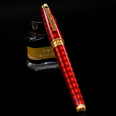 ST Dupont Olympio Vertigo Fountain Pen - Preowned capped, leaning against an ink bottle. 