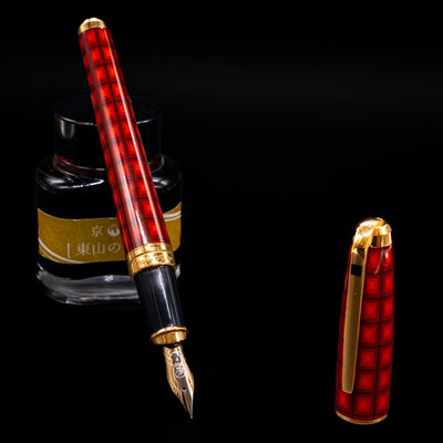 ST Dupont Olympio Vertigo Fountain Pen - Preowned leaning on an ink bottle uncapped showcasing the detailing on the nib.