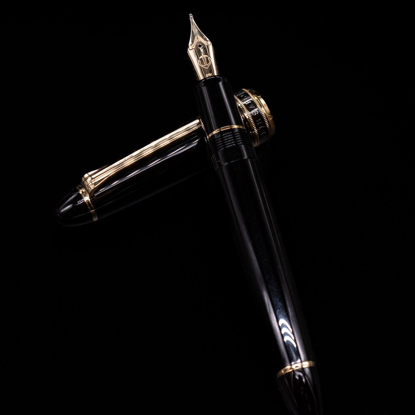 Sailor 1911L Fountain Pen - Black / King Eagle Nib laying on top of its cap in a crossed position showing full view of the entire uncapped pen.