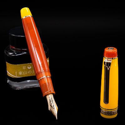 Sailor Professional Gear King of Pens Fountain Pen - Moonlight Over the Ocean leaning on an ink bottle uncapped showcasing the detailing on the nib.