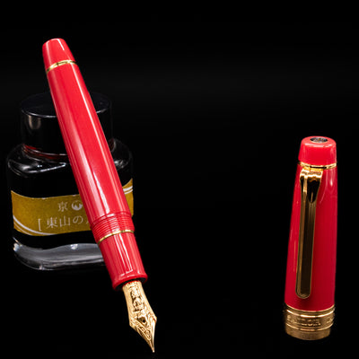 Sailor Professional Gear King of Pens Fountain Pen - Pillow Book Autumn Sky leaning on an ink bottle uncapped showcasing the detailing on the nib.