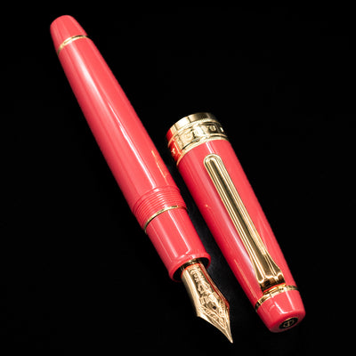  A full view of the Sailor Professional Gear King of Pens Fountain Pen - Pillow Book Autumn Sky uncapped, with its cap laying next to the pen. 