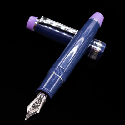 Sailor Professional Gear King of Pens Fountain Pen - Storm over the Ocean laying across its own cap, crossed, with a focus on the nib.