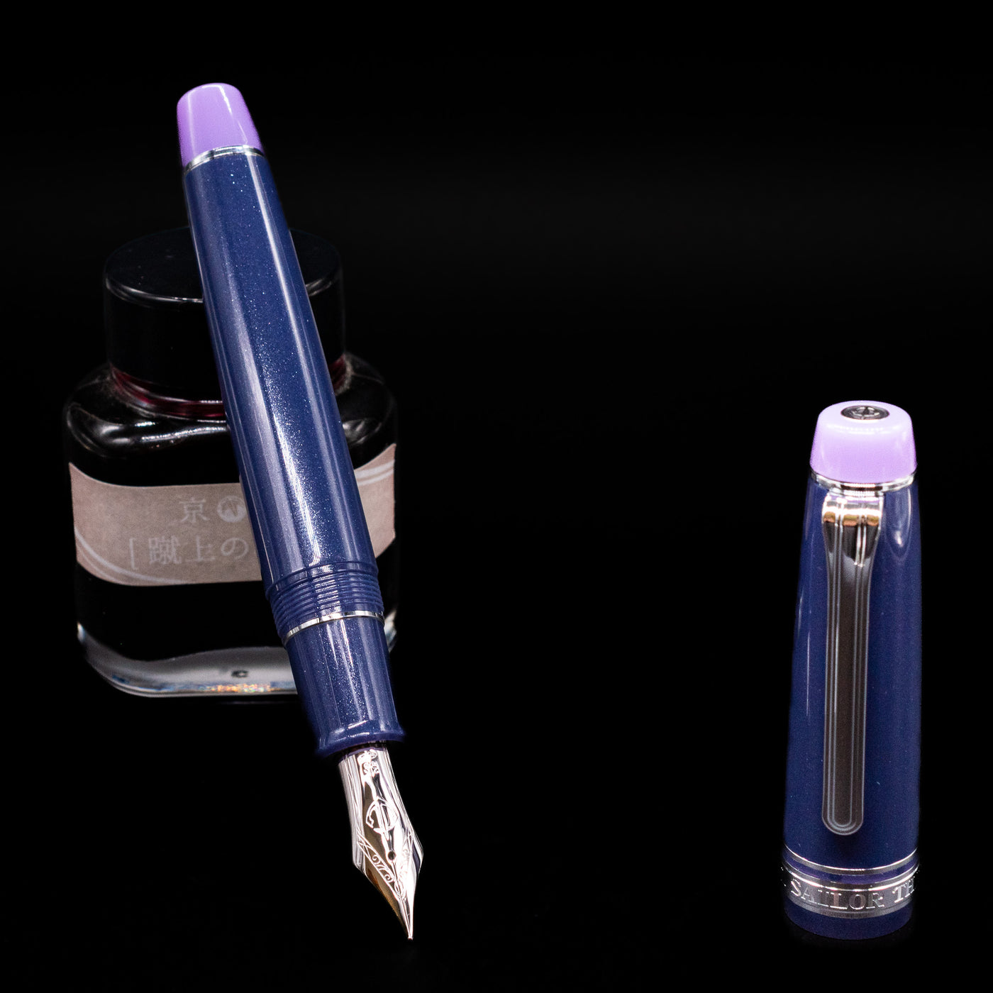Sailor Professional Gear King of Pens Fountain Pen - Storm over the Ocean  leaning on an ink bottle uncapped showcasing the detailing on the nib.