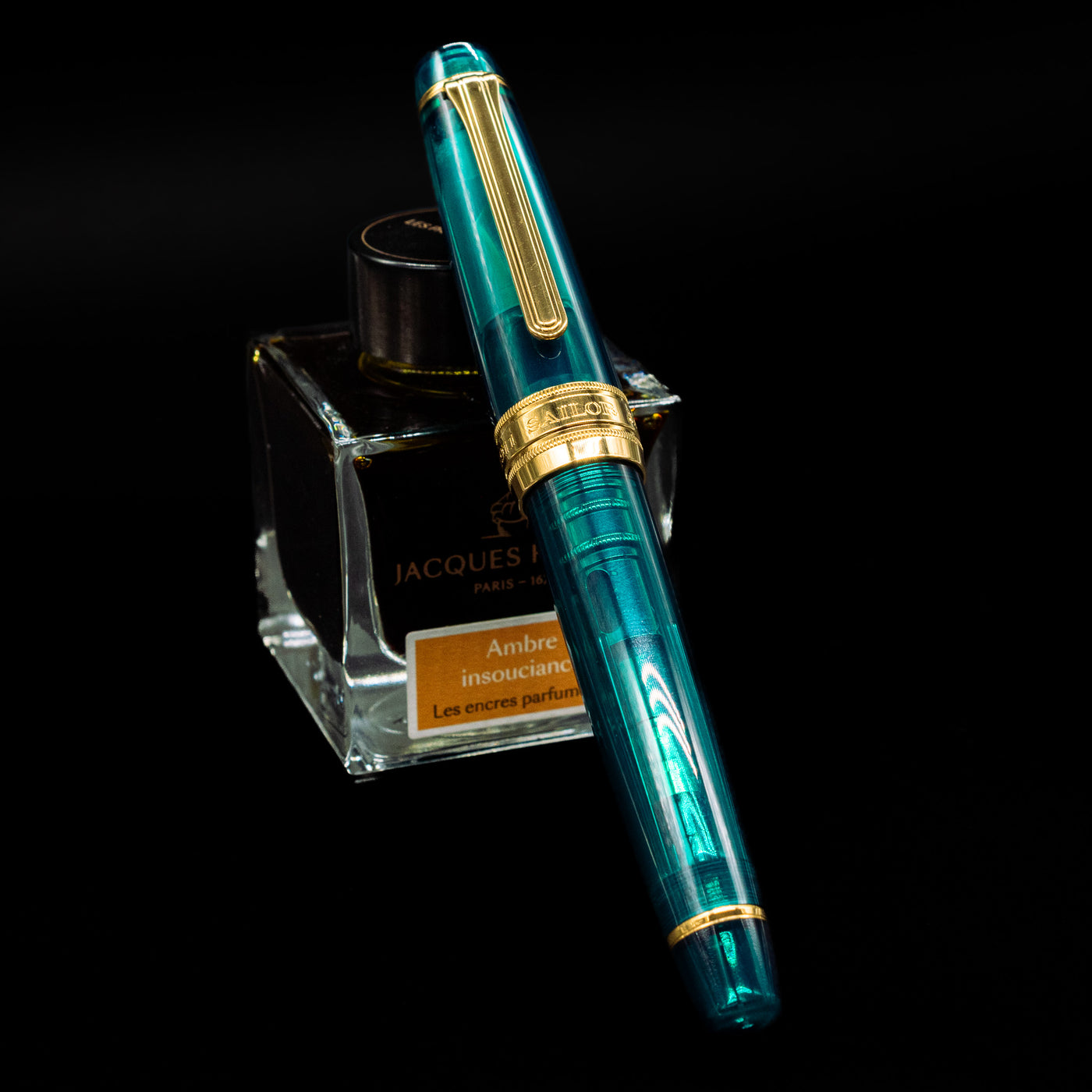 Sailor Professional Gear King of Pens Teal Green Wancher Fountain Pen - Preowned capped, leaning against an ink bottle. 