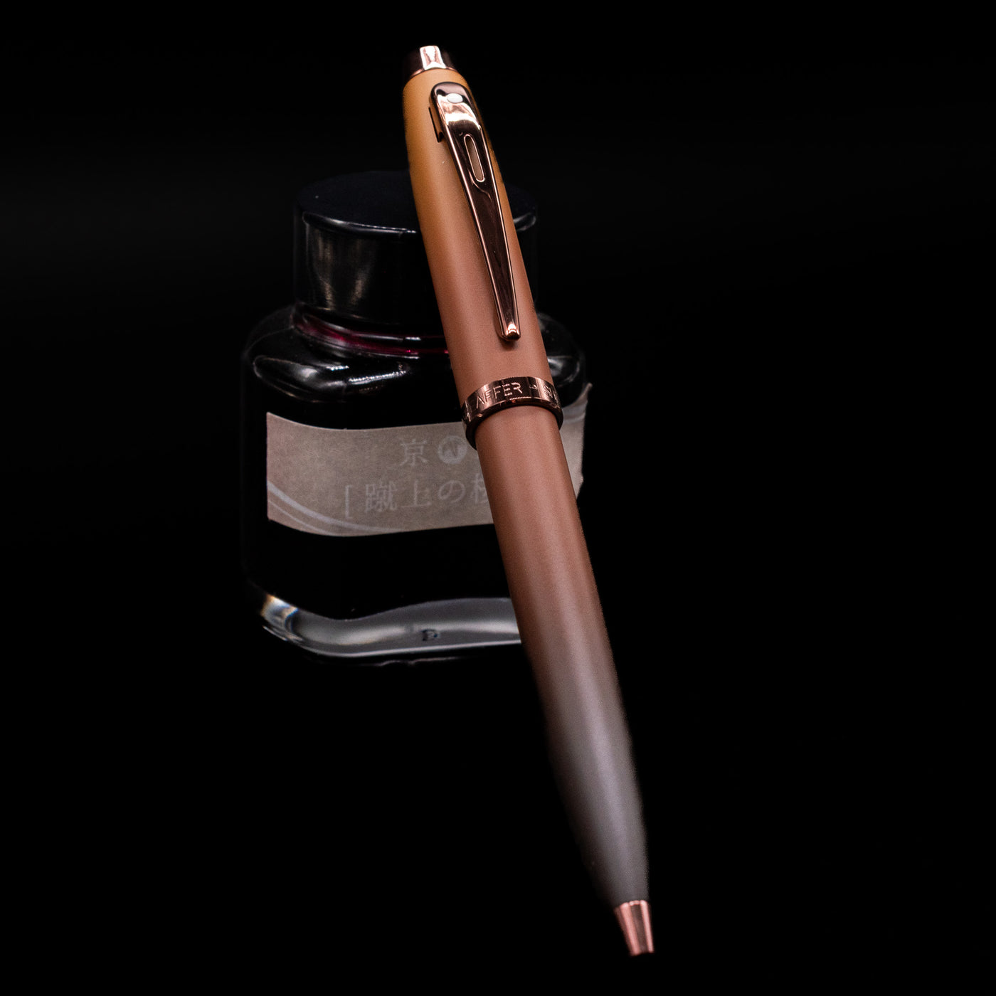 Sheaffer 100 Ballpoint Pen - Coffee (Special Edition) leaning against an ink bottle.