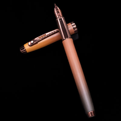 Sheaffer 100 Fountain Pen - Coffee (Special Edition) laying on top of its cap in a crossed position showing full view of the entire uncapped pen.