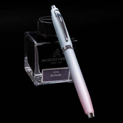 Sheaffer 100 Fountain Pen - Expressions capped, leaning against an ink bottle. 