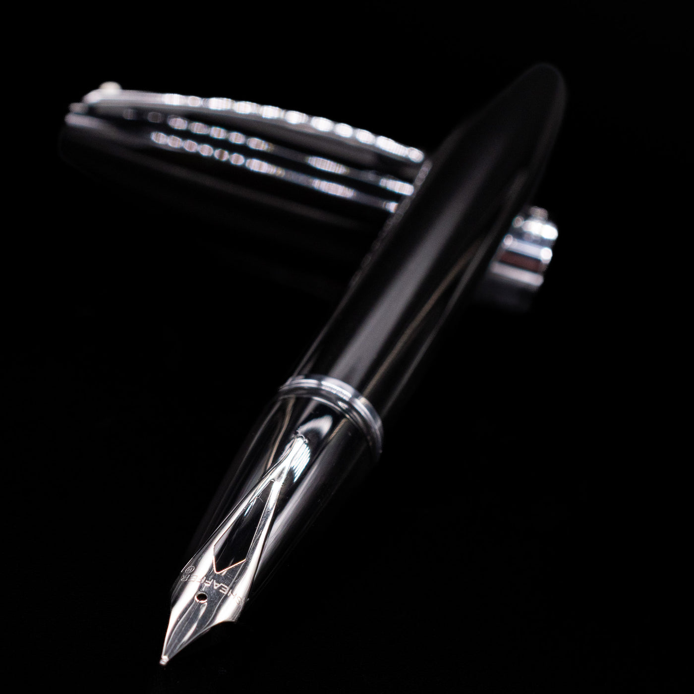 Sheaffer Legacy Fountain Pen - Black laying across its own cap, crossed, with a focus on the nib.