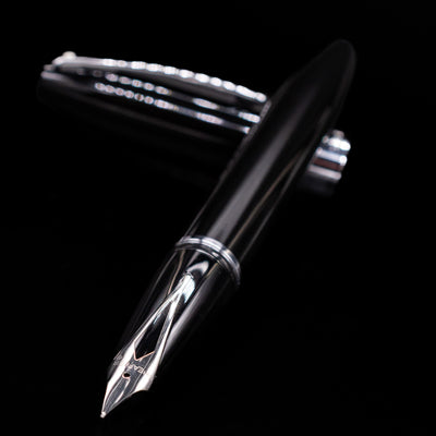 Sheaffer Legacy Fountain Pen - Black laying across its own cap, crossed, with a focus on the nib.