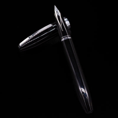 Sheaffer Legacy Fountain Pen - Black laying on top of its cap in a crossed position showing full view of the entire uncapped pen.