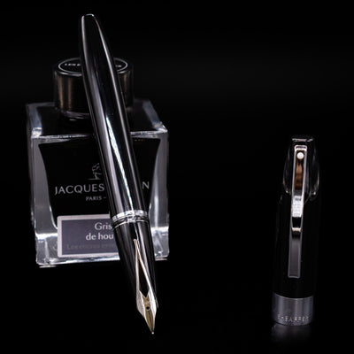 Sheaffer Legacy Fountain Pen - Black leaning on an ink bottle uncapped showcasing the detailing on the nib.