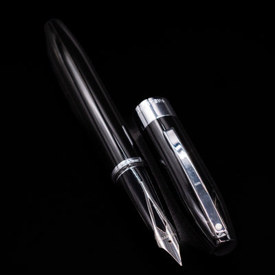 A full view of the Sheaffer Legacy Fountain Pen - Black uncapped, with its cap laying next to the pen. 
