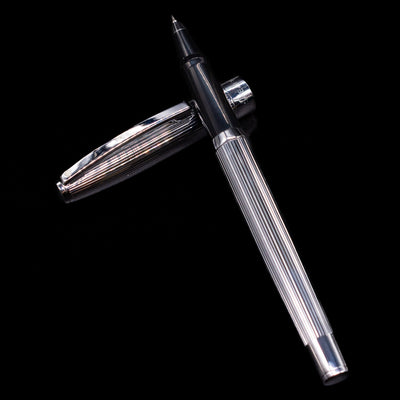Sheaffer Sagaris Rollerball Pen - Chrome laying on top of its cap in a crossed position showing full view of the entire uncapped pen.