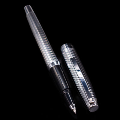 A full view of the Sheaffer Sagaris Rollerball Pen - Chrome uncapped, with its cap laying next to the pen. 