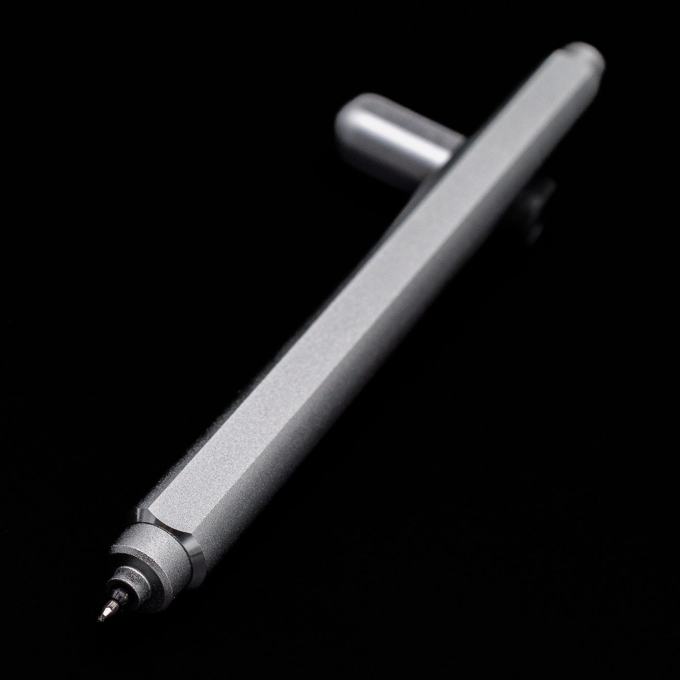 Stilform ARC Gel Pen – Comet Grey Aluminum laying across its own cap, crossed, with a focus on the nib.