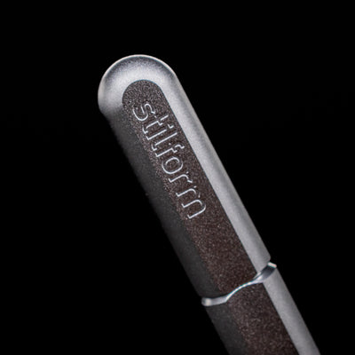 A macro shot of the logo on the cap of the Stilform ARC Gel Pen – Comet Grey Aluminum.