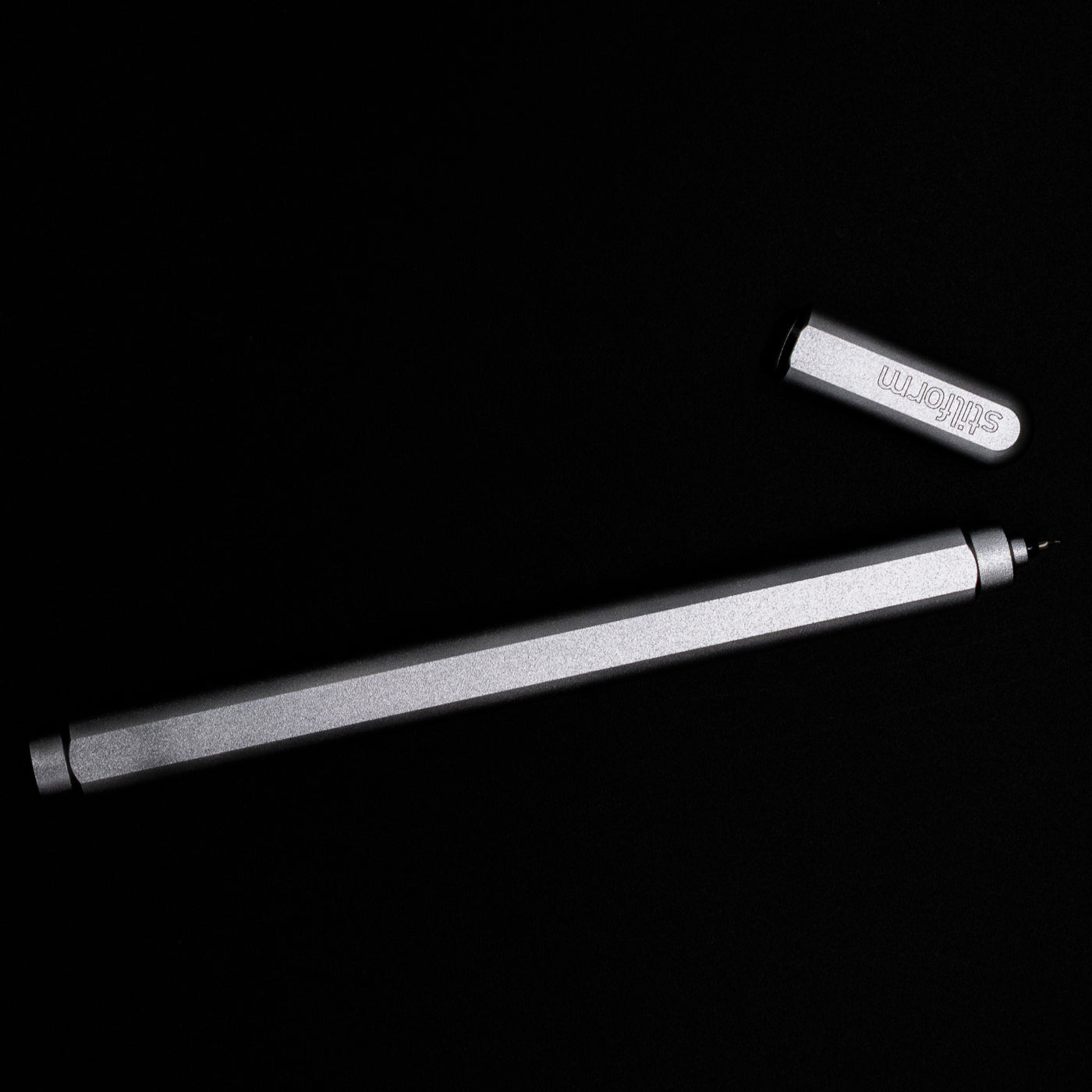 An overhead view of the Stilform ARC Gel Pen – Comet Grey Aluminum uncapped.
