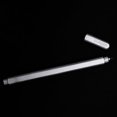 An overhead view of the Stilform ARC Gel Pen – Comet Grey Aluminum uncapped.