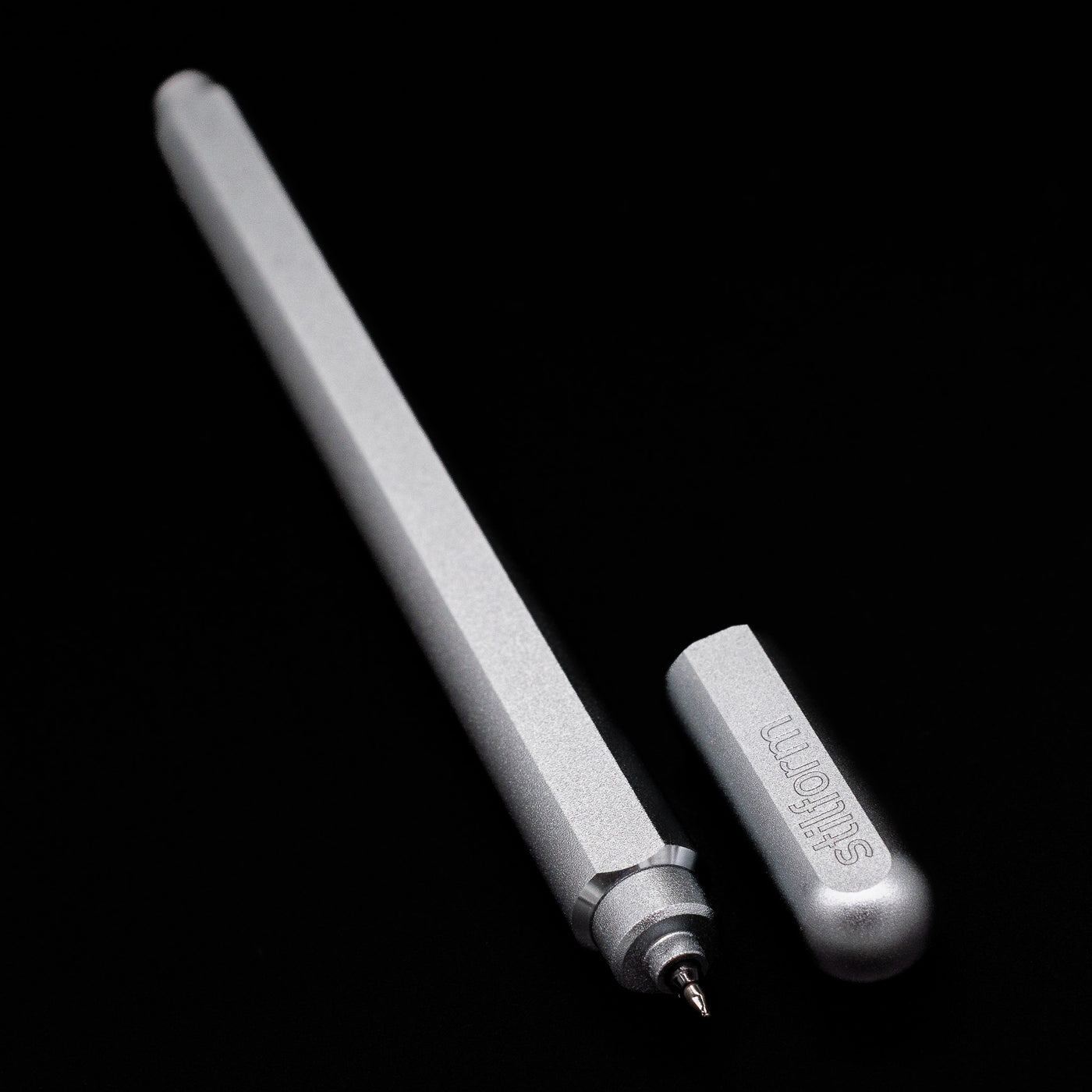 A full view of the Stilform ARC Gel Pen – Comet Grey Aluminum uncapped, with its cap laying next to the pen. 
