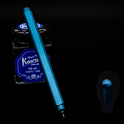 Stilform ARC Gel Pen – Night Sky Aluminum leaning on an ink bottle uncapped showcasing the tip.