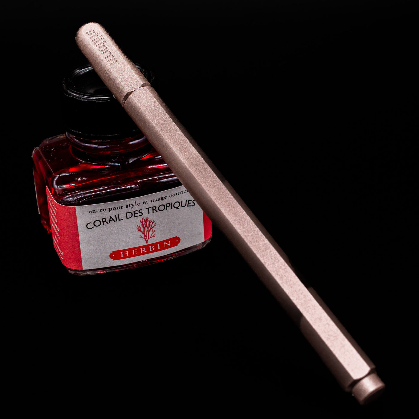 Stilform ARC Gel Pen – Rose Moon Aluminium capped, leaning on an ink bottle.
