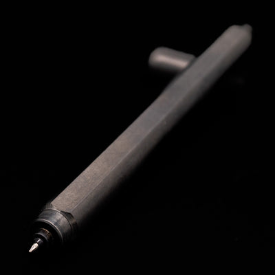 Stilform ARC Gel Pen – Titanium DLC laying across its own cap, crossed, with a focus on the tip.