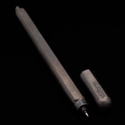  A full view of the Stilform ARC Gel Pen – Titanium DLC uncapped, with its cap laying next to the pen. 