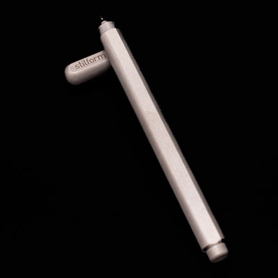 Stilform ARC Gel Pen – Titanium Matte laying on top of its cap in a crossed position showing full view of the entire uncapped pen.
