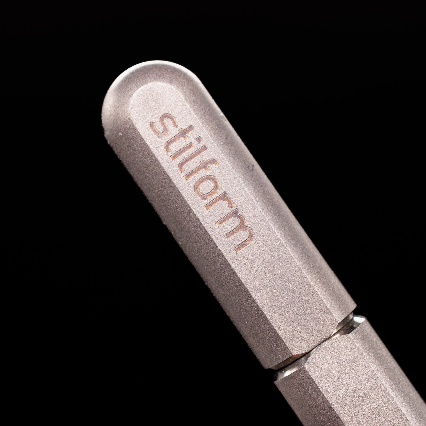 A macro shot of the logo on the cap of the Stilform ARC Gel Pen – Titanium Matte.