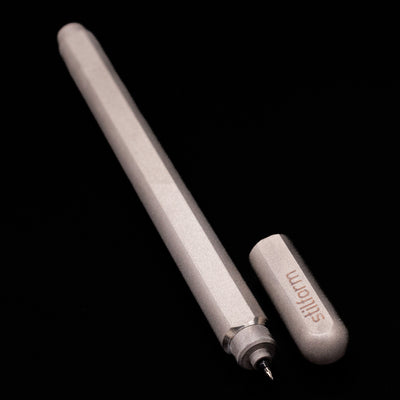 A full view of the Stilform ARC Gel Pen – Titanium Matte uncapped, with its cap laying next to the pen. 