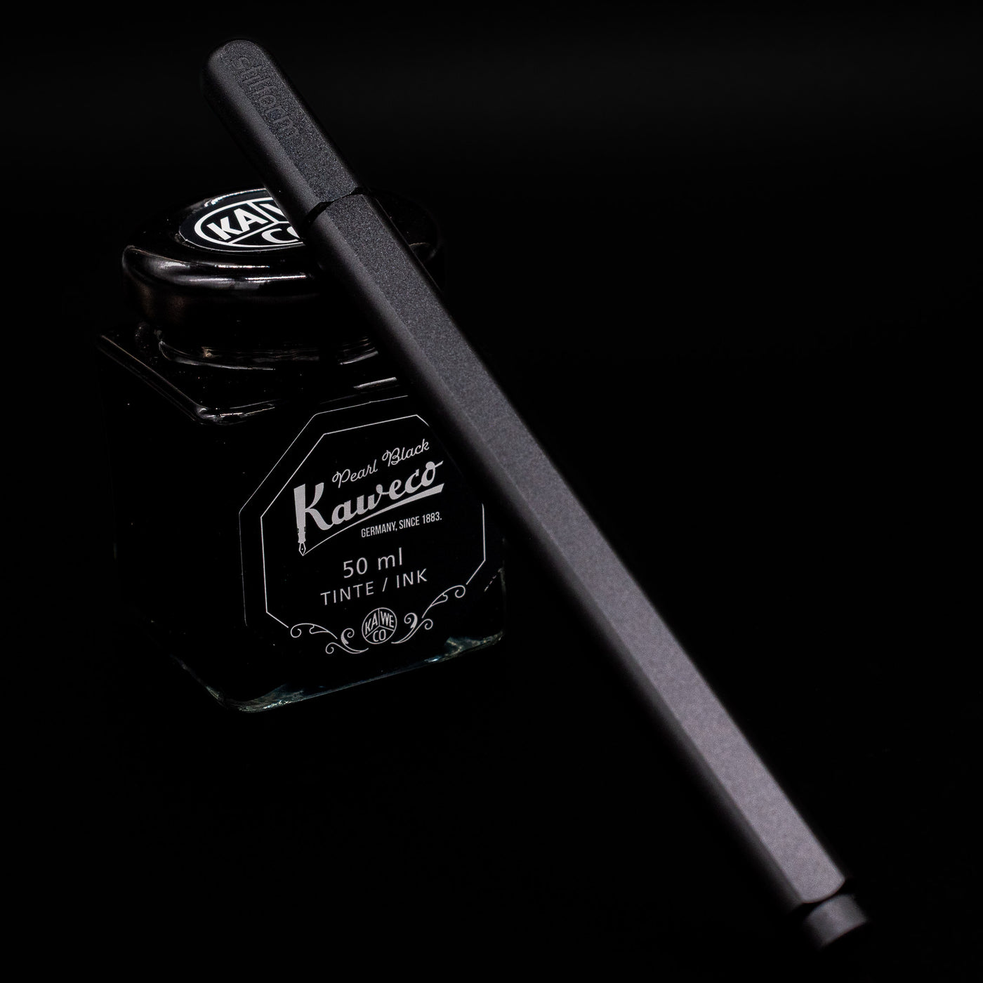 Stilform ARC Gel Pen – Warp Black Aluminum capped, leaning against an ink bottle. 