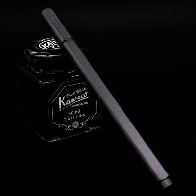 Stilform ARC Gel Pen – Warp Black Aluminum capped, leaning against an ink bottle. 