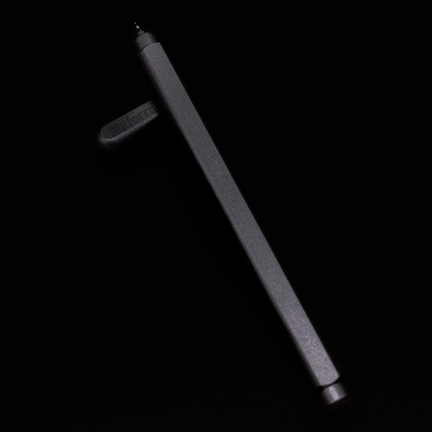 Stilform ARC Gel Pen – Warp Black Aluminum laying on top of its cap in a crossed position showing full view of the entire uncapped pen.