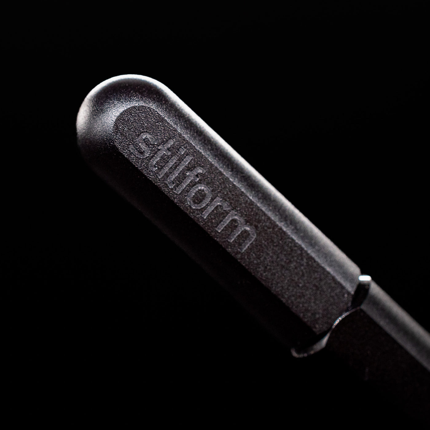 A macro shot of the logo on the cap of the Stilform ARC Gel Pen – Warp Black Aluminum.