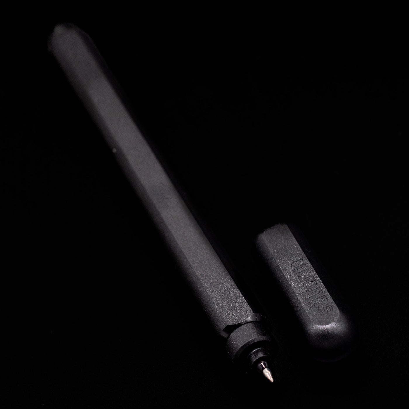 A full view of the Stilform ARC Gel Pen – Warp Black Aluminum uncapped, with its cap laying next to the pen. 