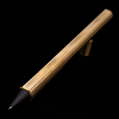 Stilform FLOW Rollerball Pen – Brass Radial Brushed laying propped up at an angle, with a focus on the tip.