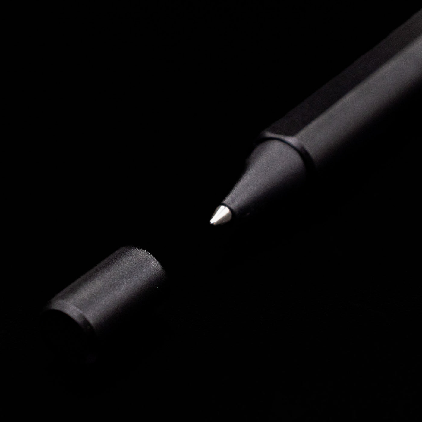 A macro shot of the Stilform FLOW Rollerball Pen – Warp Black Aluminum's tip and small cap.