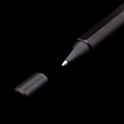 A macro shot of the Stilform FLOW Rollerball Pen – Warp Black Aluminum's tip and small cap.