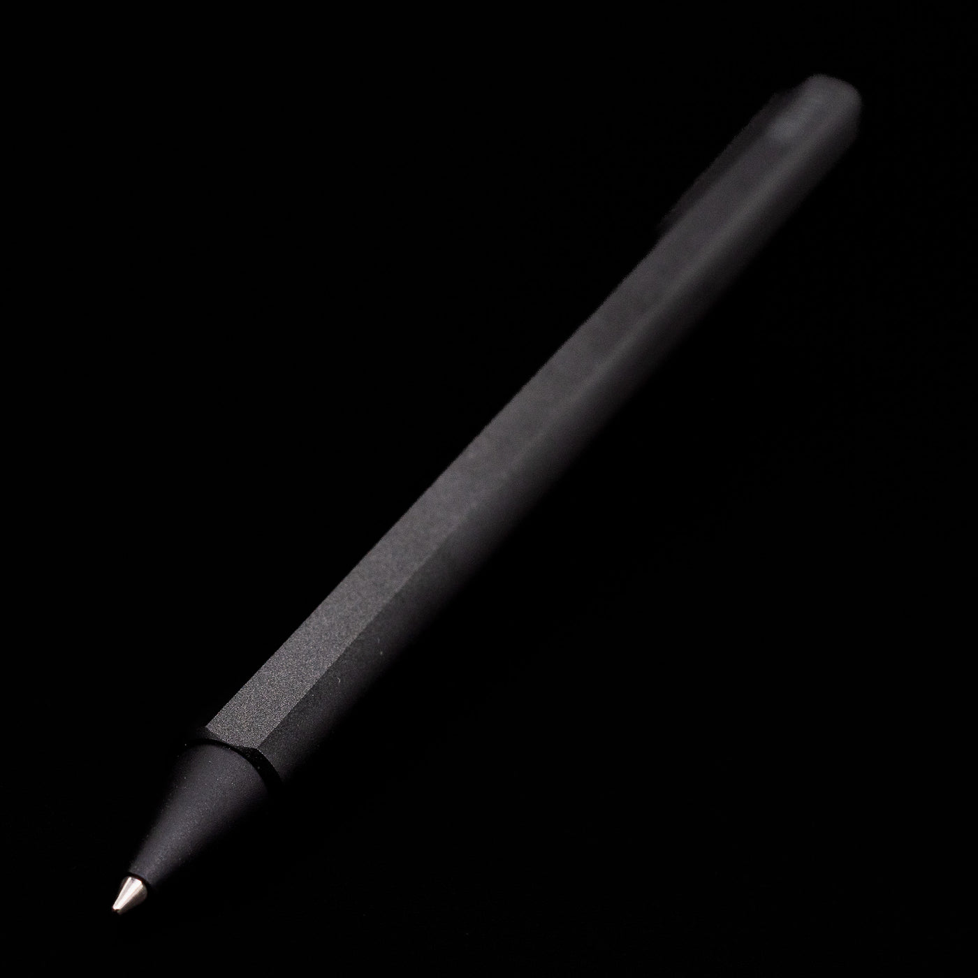 Full view of the Stilform FLOW Rollerball Pen – Warp Black Aluminum at an angle with a focus on its tip.